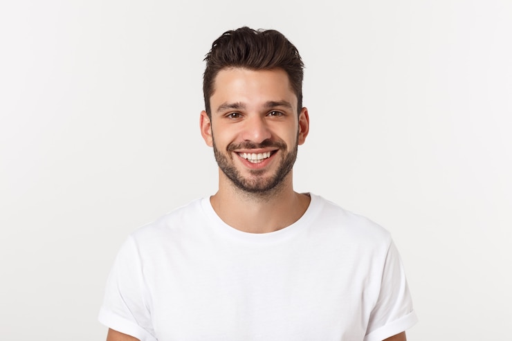 Photo portrait d'un beau jeune homme souriant contre le mur jaune