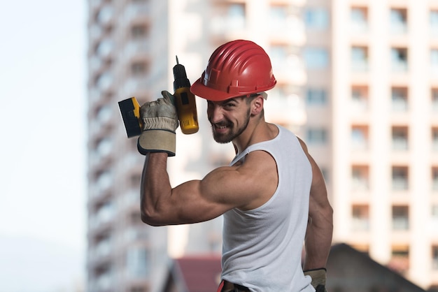 Portrait de beau mâle ingénieur architecte avec casque rouge