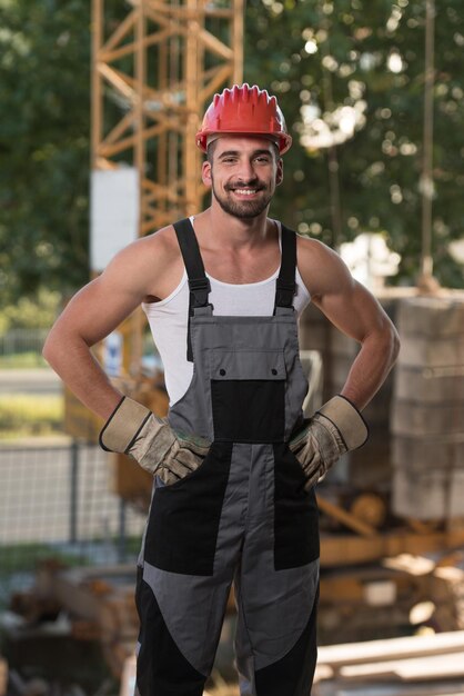 Portrait de beau mâle ingénieur architecte avec casque rouge