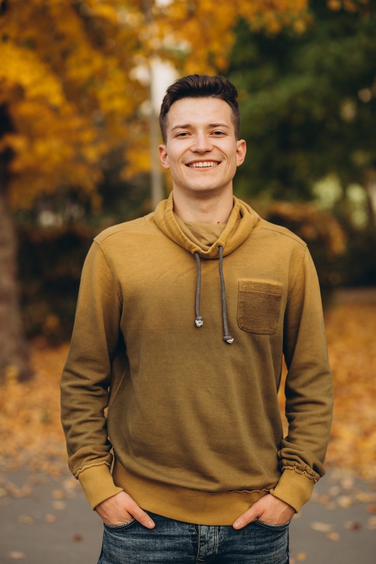 Photo portrait de beau mec souriant dans le parc de l'automne