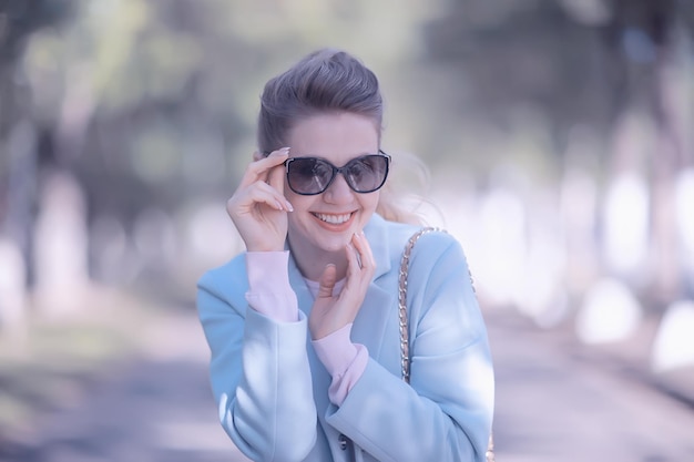 portrait d'un beau modèle féminin européen portant des lunettes de soleil / fille marchant à l'extérieur, joyeuse fille portant des lunettes