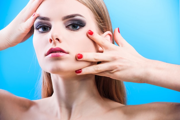 Portrait de beau modèle féminin sur fond bleu