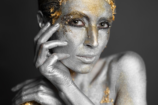 Portrait D'un Beau Modèle Féminin Avec De La Peinture Or Et Argent Sur Sa Peau Et Ses Cheveux En Studio