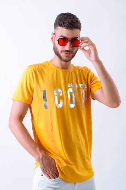 Portrait de beau modèle de jeune homme élégant souriant vêtu du Tshirt jaune fashion man pos