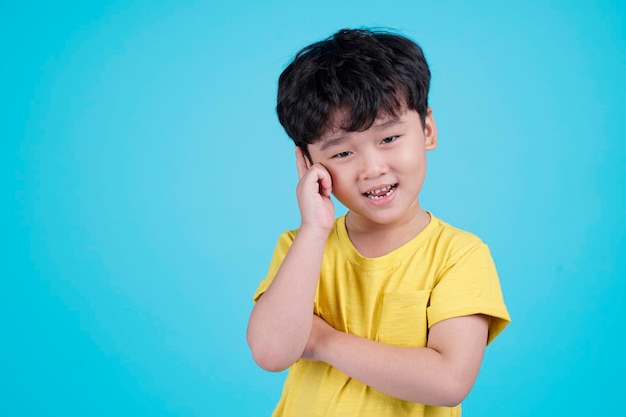 Portrait d'un beau petit garçon asiatique isolé sur fond bleu