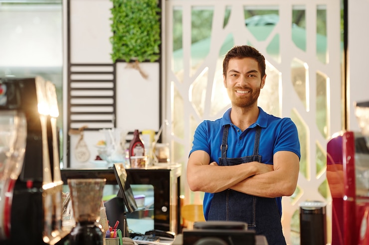Photo portrait de beau souriant coffeeshop barista bras pliants