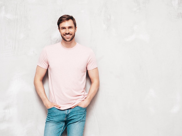 Portrait, de, beau, souriant, élégant, hipster, lambersexual, modèle, sexy, homme, habillé, dans, t-shirt, et, jeans, mode, mâle, isolé, sur, mur bleu, dans, studio