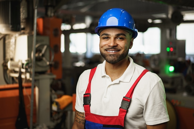 Portrait d'un beau travailleur d'usine afro-américain souriant