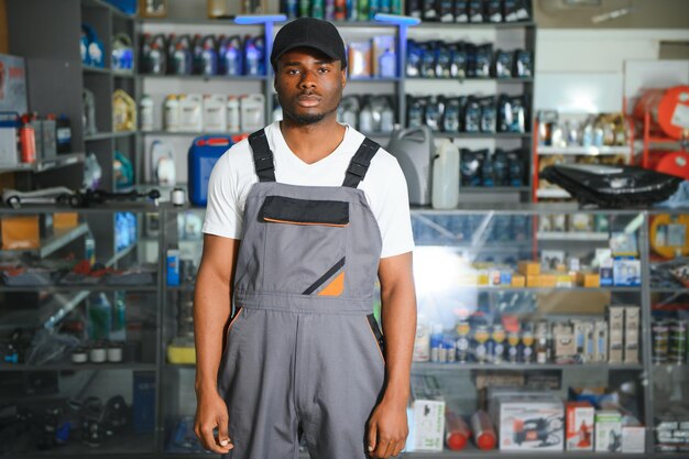 Portrait d'un beau vendeur africain dans un magasin de pièces automobiles Le concept de réparation de voitures