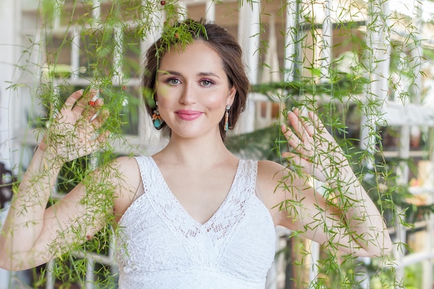 Portrait de beauté d'une belle femme heureuse brune souriante sur fond de feuilles vertes