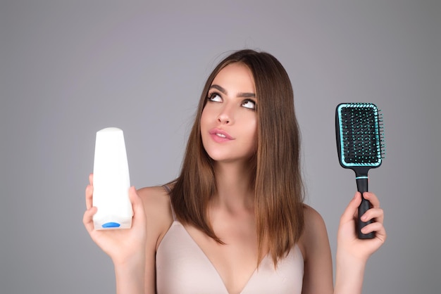 Portrait de beauté une belle fille à la peau propre tient un tube de modèle dans ses mains femmes soin des cheveux