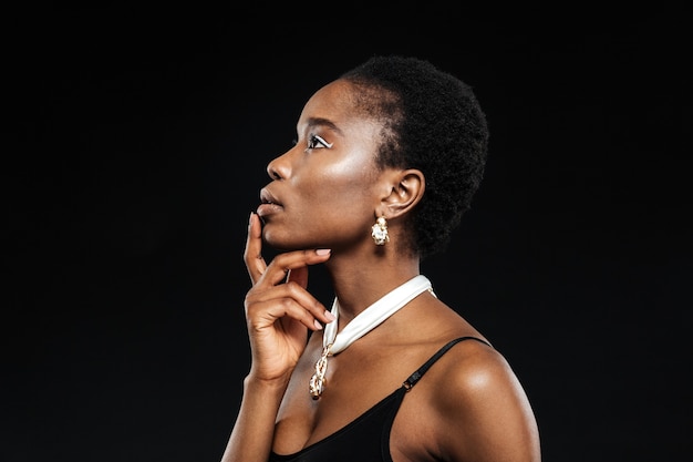 Portrait de beauté de la belle jeune femme ethnique isolée sur le mur noir