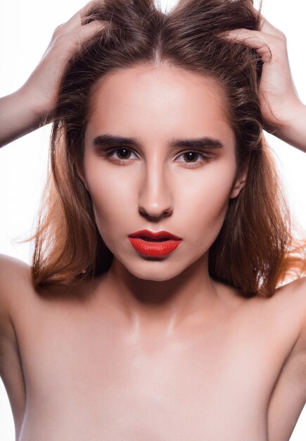 Portrait de beauté du modèle brune à la mode avec une peau parfaite et des lèvres rouges. Prise de vue en studio sur fond blanc