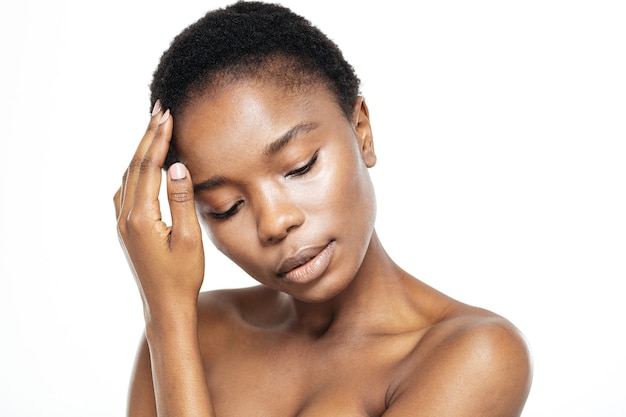 Portrait de beauté d'une femme afro-américaine détendue avec une peau fraîche isolée sur fond blanc