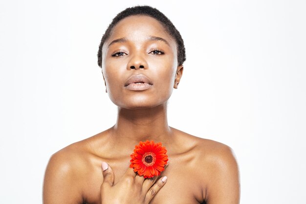 Portrait de beauté d'une femme afro-américaine posant avec une fleur isolée sur fond blanc