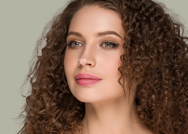 Portrait De Beauté Femme Cheveux Longs Bouclés Brune, Visage Glamour Féminin. Couleur Fond Vert