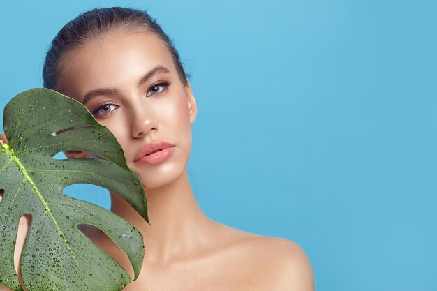 Portrait de beauté d'une femme d'ethnie caucasienne avec une peau propre sur un bleu isolé avec une copie gratuite