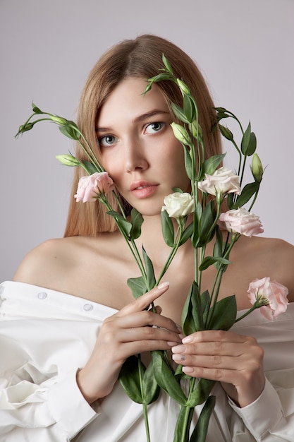 Portrait de beauté femme avec des fleurs d'eustoma rose dans les mains