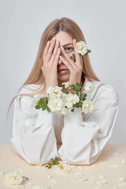 Portrait de beauté d'une femme avec des fleurs roses dans ses mains