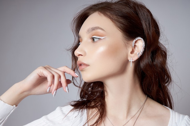 Portrait de beauté d'une femme avec un maquillage naturel et peint des ongles polis sur sa main.