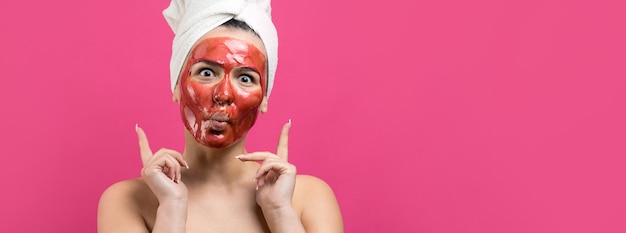 Portrait de beauté d'une femme en serviette blanche sur la tête avec un masque nourrissant doré sur le visage