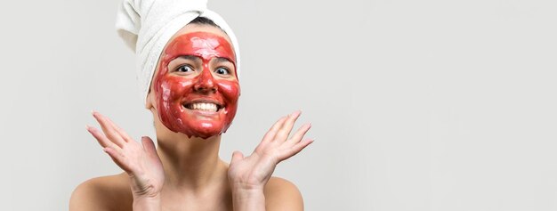 Portrait de beauté d'une femme en serviette blanche sur la tête avec un masque nourrissant doré sur le visage