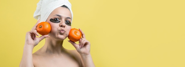 Portrait de beauté d'une femme en serviette blanche sur la tête avec un masque nourrissant doré sur le visage