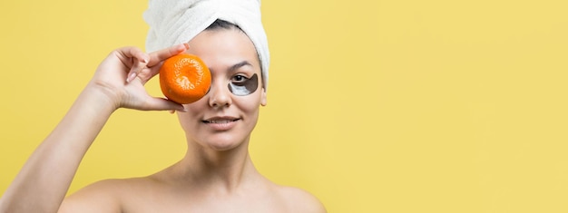 Portrait de beauté d'une femme en serviette blanche sur la tête avec un masque nourrissant doré sur le visage