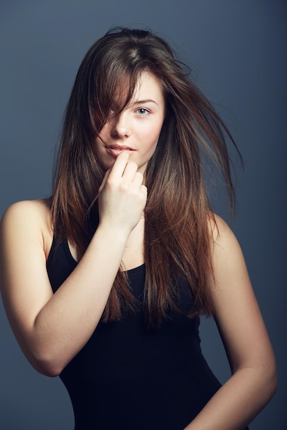 Portrait beauté et femme avec volume de soins capillaires et modèle confiant sur un fond de studio sombre Visage femme et fille avec texture cosmétiques et coiffure avec croissance et traitement