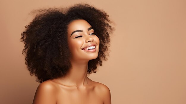 Portrait de beauté d'une fille afro-américaine avec une peau propre et saine sur fond beige Souriante belle femme noire de rêveCheveux bouclés dans un style afro