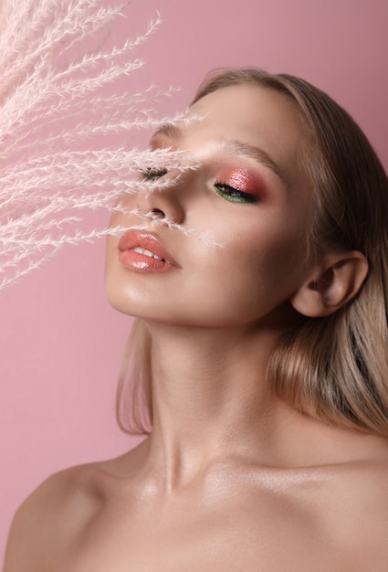 Portrait de beauté d'une fille avec un maquillage parfait sur son visage, ombre à paupières colorée, longs beaux cheveux