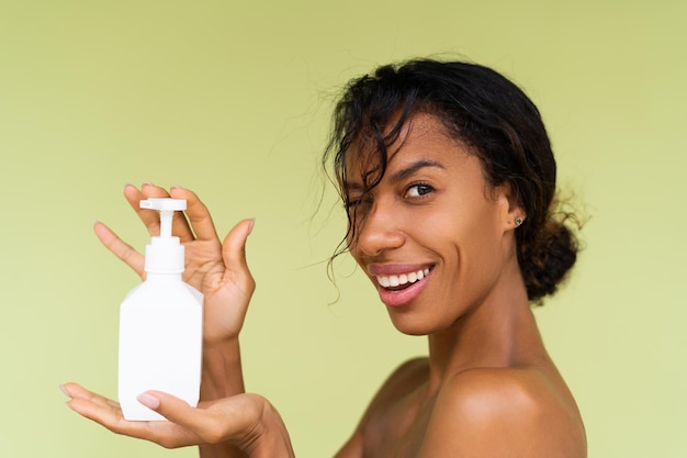 Portrait de beauté d'une jeune femme afro-américaine aux seins nus avec des épaules nues sur fond vert avec