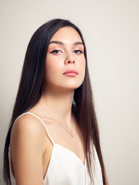 Portrait de beauté d'une jeune femme brune sur fond blanc