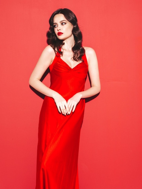 Portrait de beauté d'une jeune femme brune avec un maquillage de soirée et une peau parfaitement propre Modèle sexy aux cheveux bouclés qui pose en studio Avec des lèvres naturelles rouges brillantes