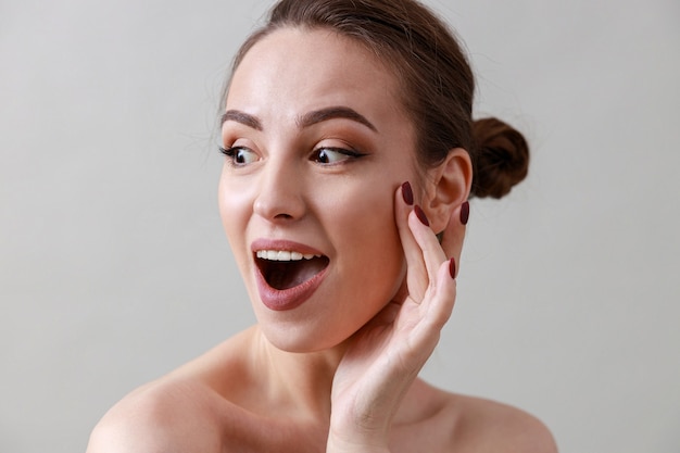 portrait de beauté d'une jeune femme caucasienne en bonne santé, belle et fraîche sur un mur gris