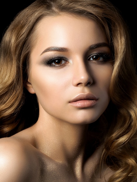 Portrait de beauté de jeune femme avec du maquillage doré