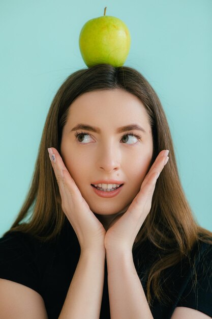 Portrait de beauté d'une jeune fille asiatique souriante tenant une pomme verte