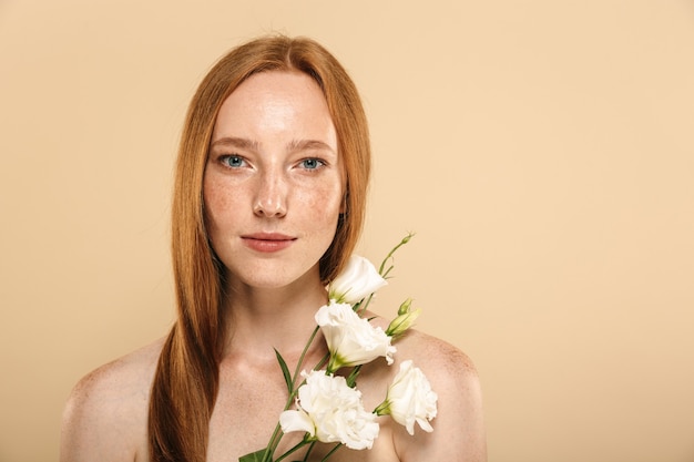 Portrait de beauté d'une jeune rousse aux seins nus souriante