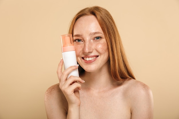 Portrait de beauté d'une jeune rousse aux seins nus souriante