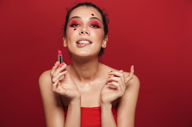 Portrait de beauté d'une jolie jeune femme aux seins nus portant du maquillage debout isolé