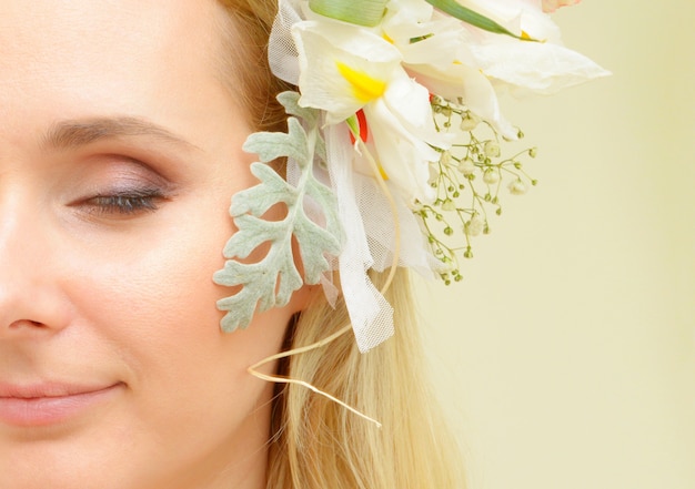 Portrait de beauté mode créative de la belle jeune femme avec une coiffure de fleur. fille modèle avec maquillage professionnel. portrait créatif de femme avec des fleurs