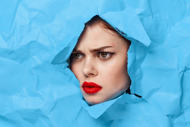 Portrait de beauté de mode femme à partir de parties de papier bleu de couleur déchirées du visage