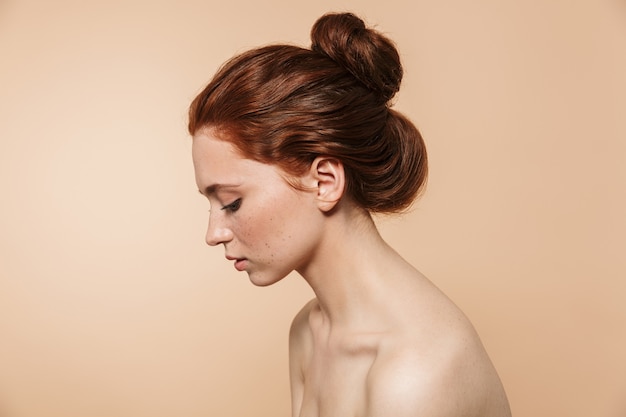 Portrait de beauté d'une séduisante jeune femme rousse aux seins nus sensuelle debout isolée, posant