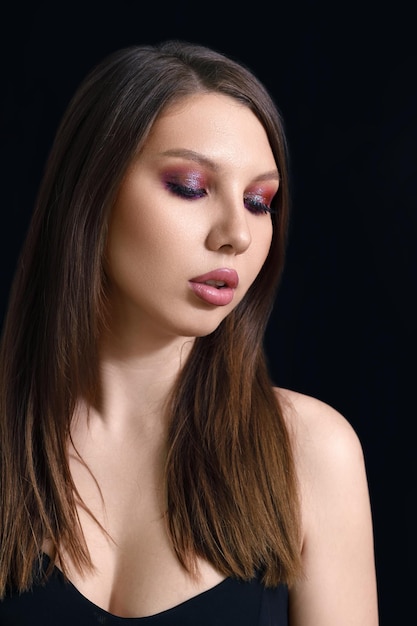 Portrait de beauté vertical d'une femme brune sur fond noir