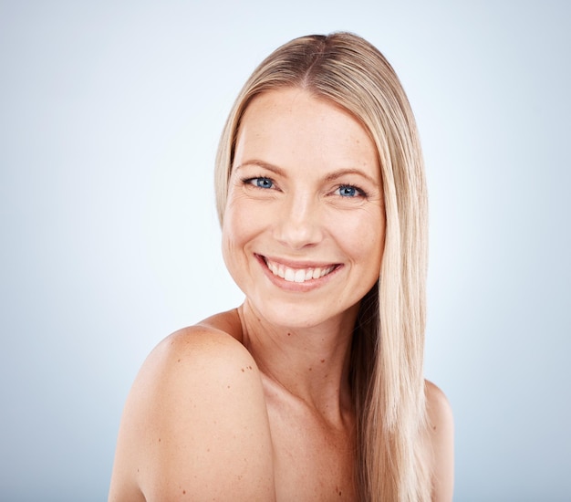 Portrait de beauté et visage d'une femme pour la santé et le bien-être des soins de la peau sur fond de studio gris Cosmotologie avant et soins de la peau ou soins du corps pour une femme à la peau douce et lisse