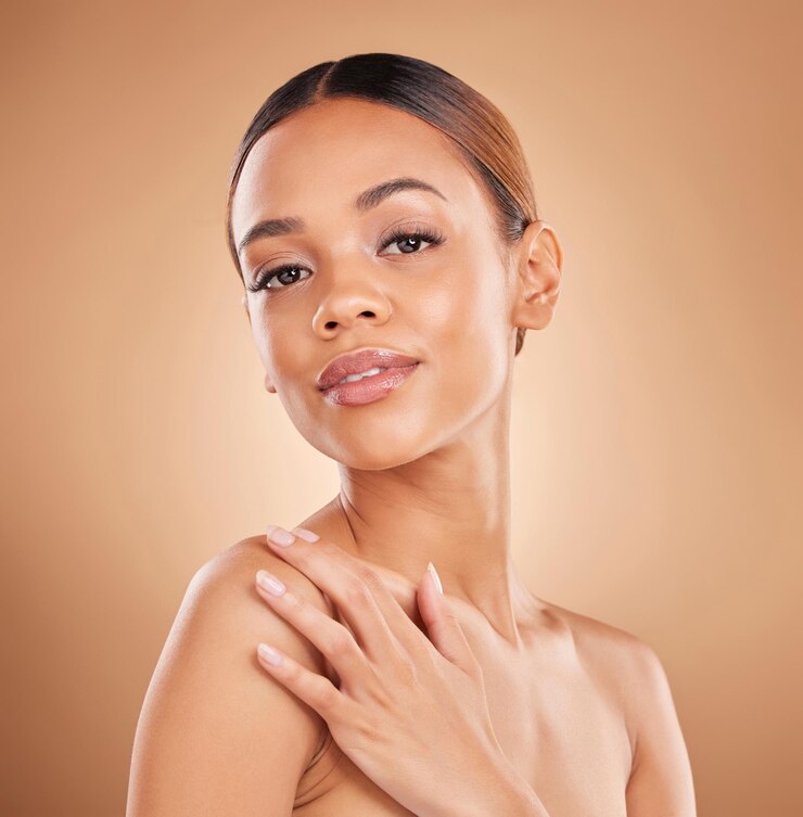 Photo portrait de beauté et un visage de femme avec des soins de la peau brillent et brillent en studio sur un fond marron main de modèle féminin esthétique pour les résultats de cosmétiques et de bien-être de dermatologie naturelle du visage spa