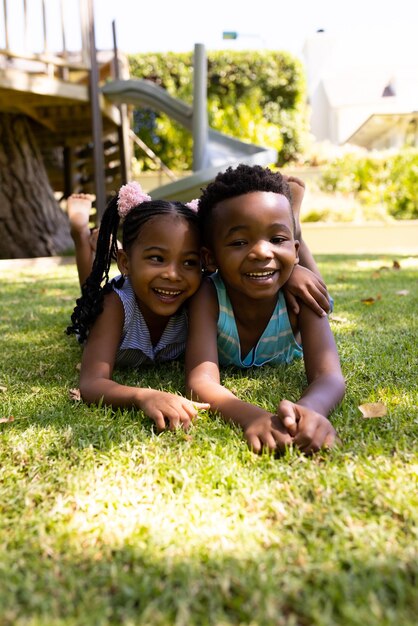 Photo portrait de beaux frères et sœurs afro-américains allongés sur un champ herbeux dans un parc