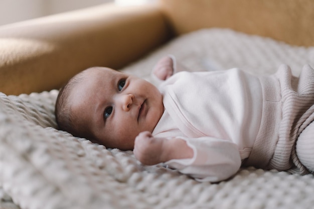 Portrait d'un bébé de 1 mois mignon nouveau-né allongé sur un tapis en développement