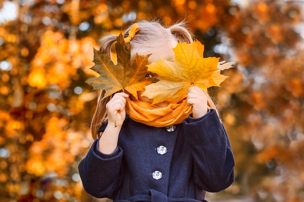 Portrait de bébé d'automne en automne jaune laisse des vêtements pour la saison d'octobre