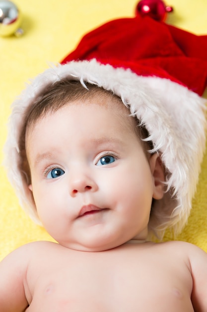 Portrait de bébé dans un bonnet rouge avec des boules